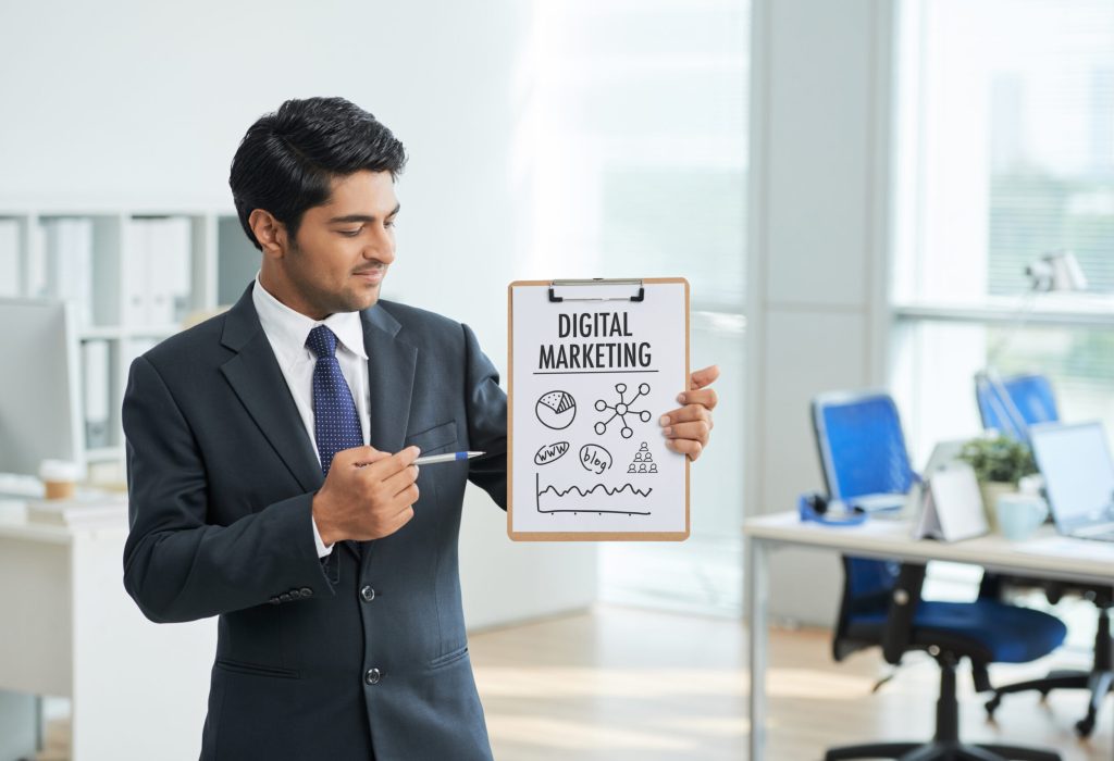 man-suit-standing-office-with-clipboard-pointing-poster-with-words